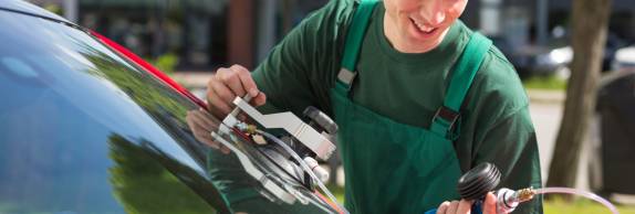 Glazier repairing windscreen after stone chipping damage